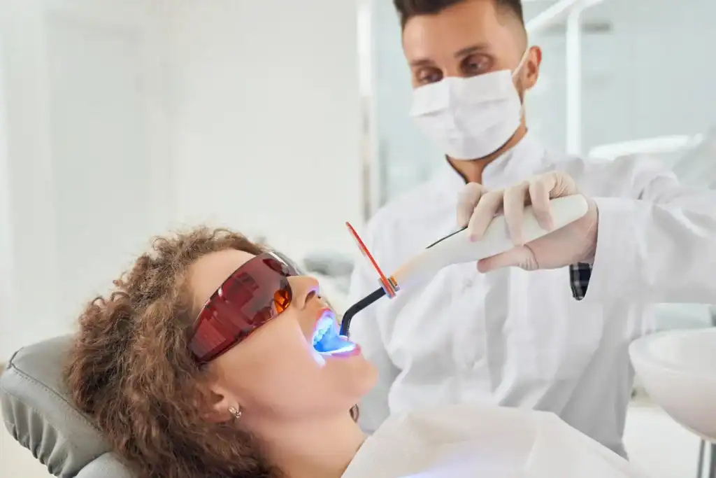 Woman receiving professional Laser Teeth Whitening treatment with safety glasses Bognor Regis